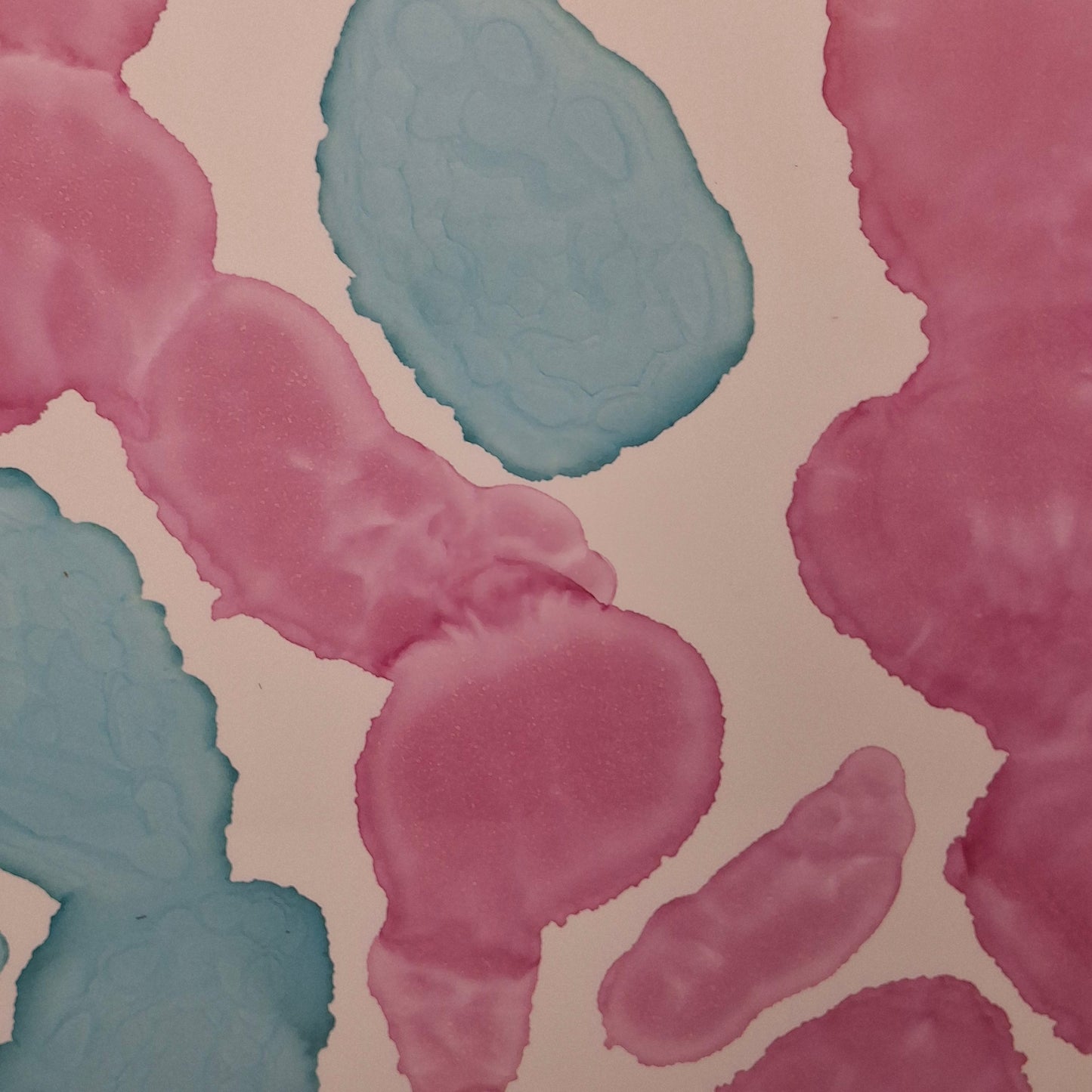 Framed abstract alcohol ink painting titled Currents of Love by Elizabeth Marshall, featuring organic flowing shapes in soft blue and vibrant pink, evoking coral reefs and ocean currents.