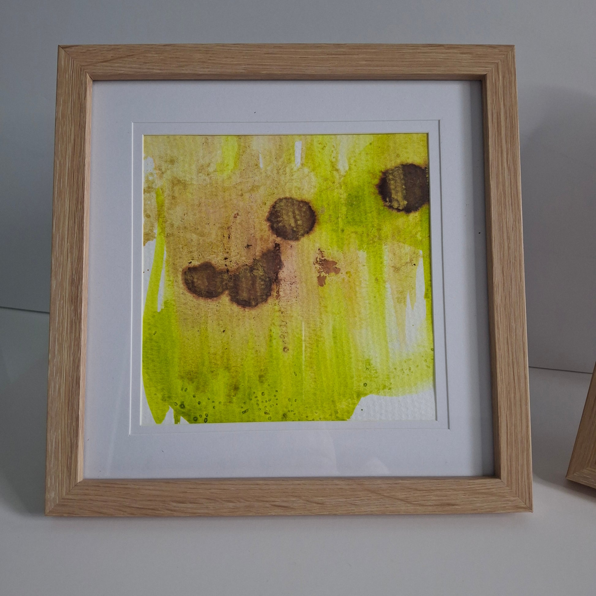 Single artwork with soft yellow-green background and four brown organic shapes.