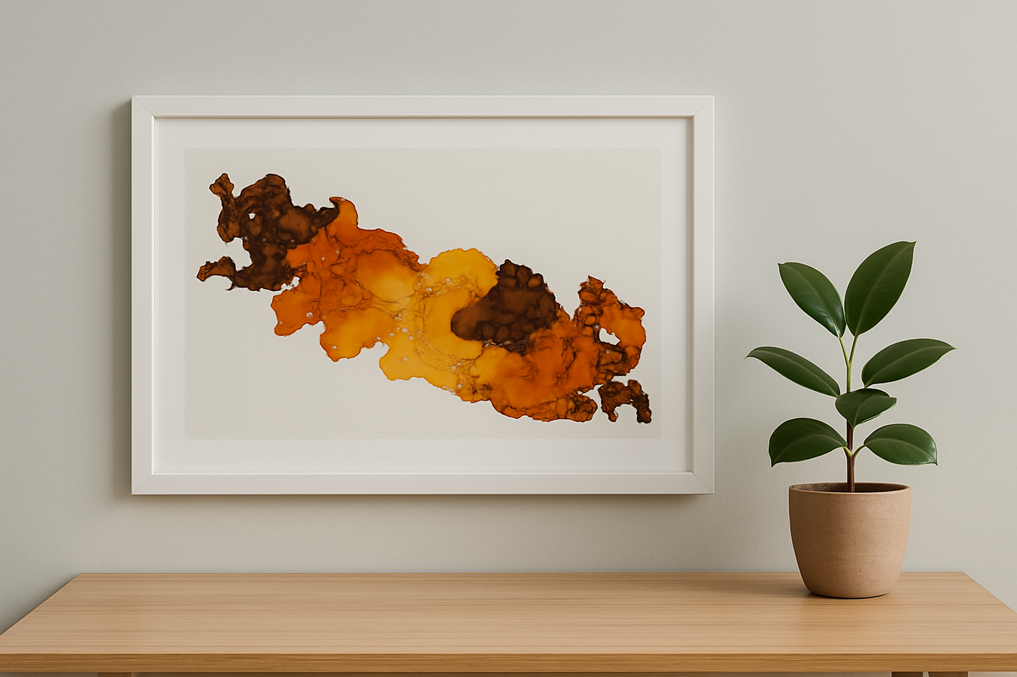 Framed abstract artwork with warm colors on a wall above a wooden surface with a plant.