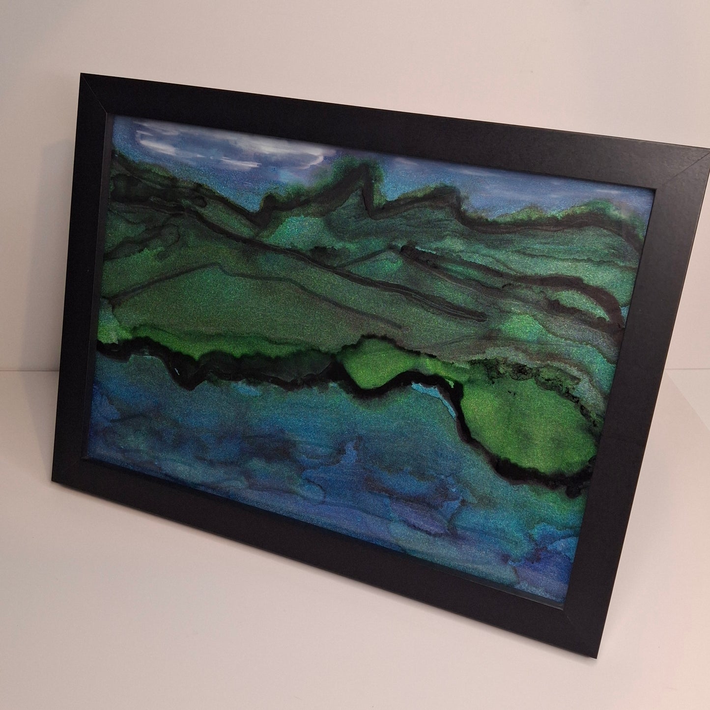 Alcohol ink artwork of Otago’s hills meeting the ocean in green and blue tones