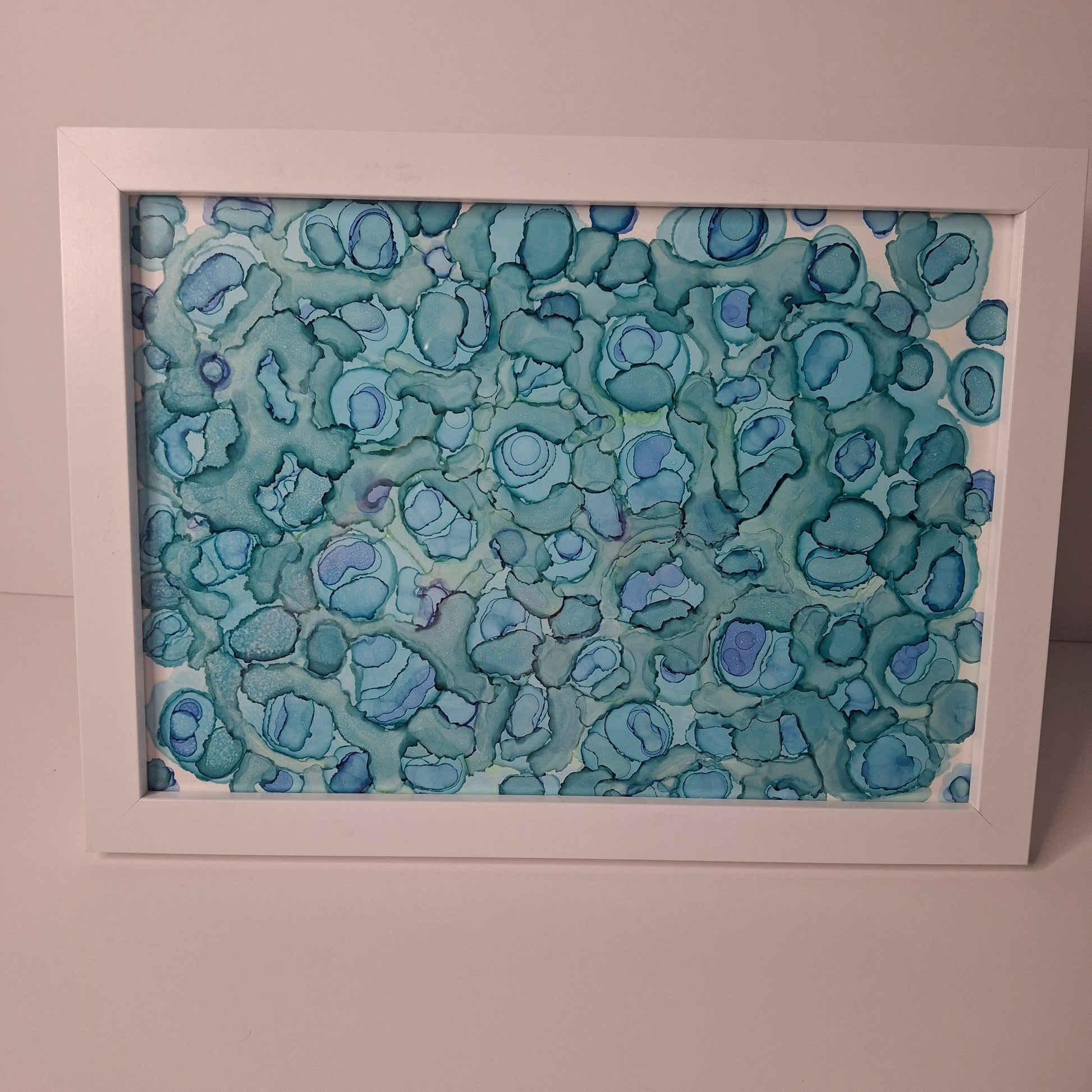 Framed artwork with a blue pattern on a white background