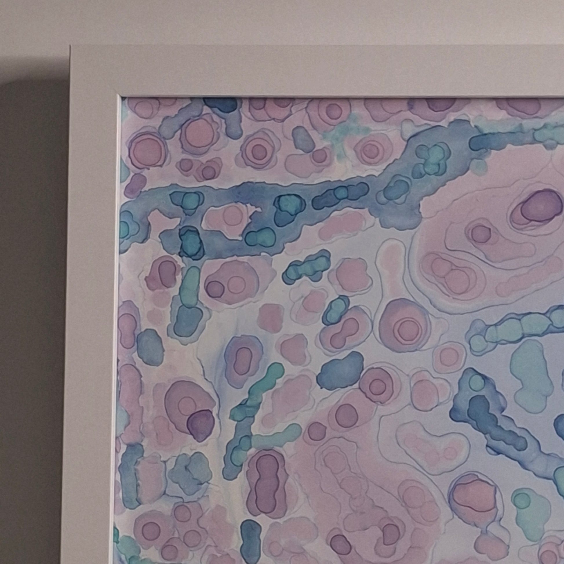 Framed abstract artwork with pastel colors on a light background