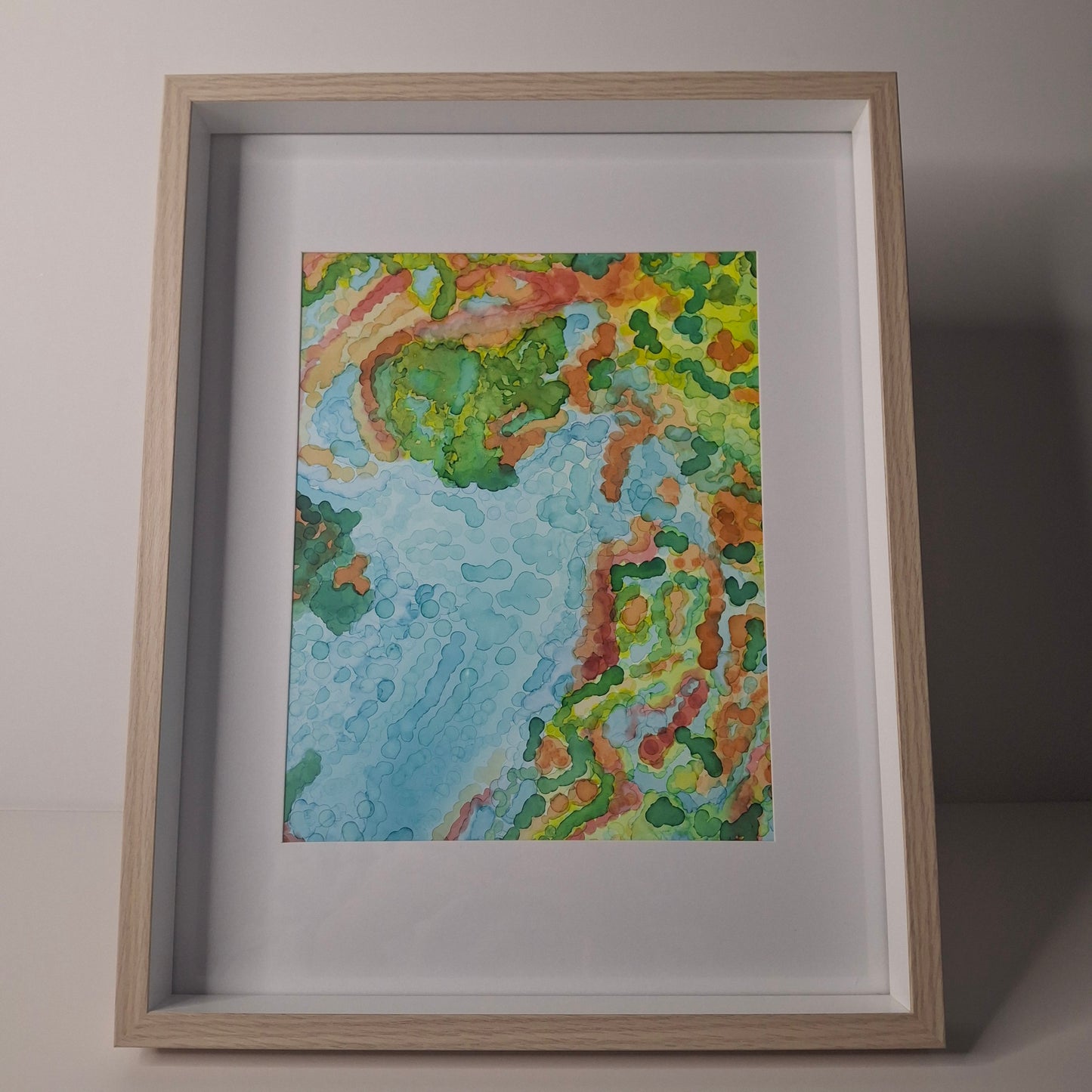 Reef Dreaming artwork from the Sea Is My Lover series by Elizabeth Marshall, displayed in a light wood frame with white matting.