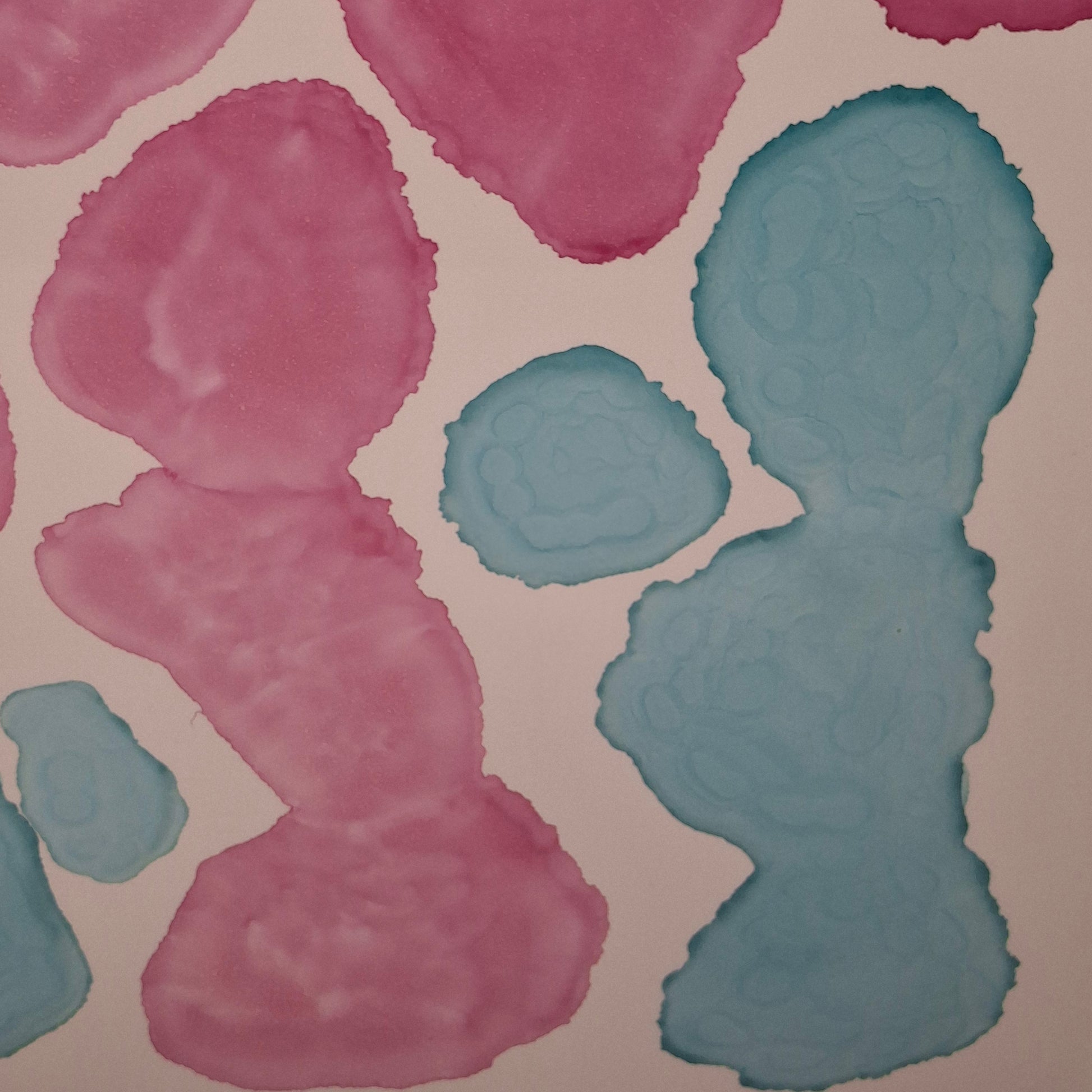 Framed abstract alcohol ink painting titled Currents of Love by Elizabeth Marshall, featuring organic flowing shapes in soft blue and vibrant pink, evoking coral reefs and ocean currents.