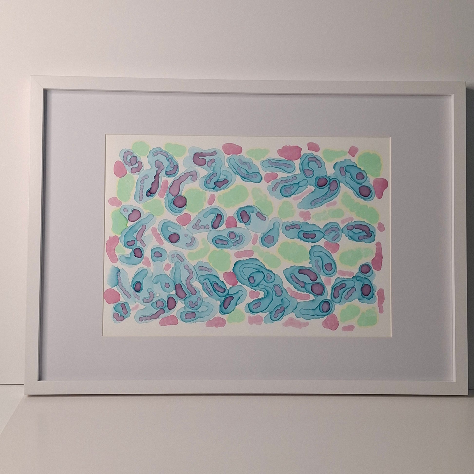 Framed abstract alcohol ink artwork in blue, green, and soft warm tones with organic circular shapes, titled “Tidepool Waltz” by Elizabeth Marshall.